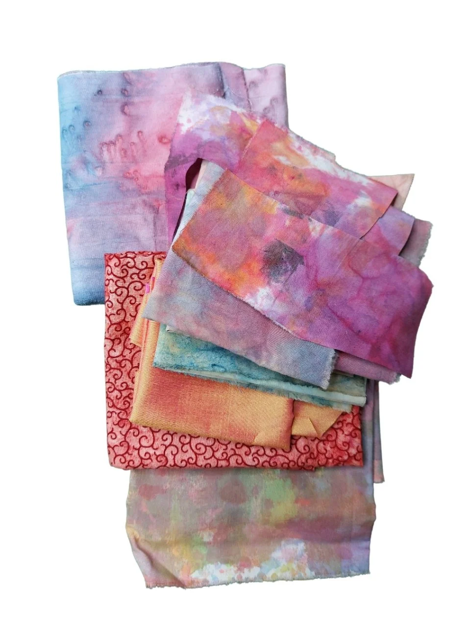 Set of folded fabric pieces with watercolor patterns in pastel pink, purple, blue, and yellow hues.