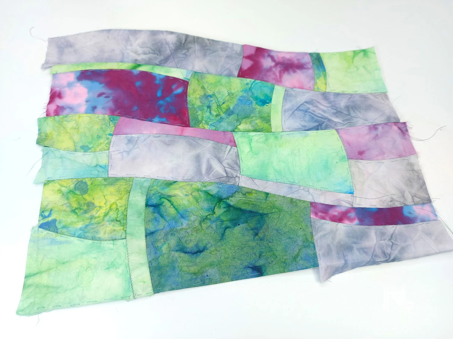 Colourful patchwork landscape quilt made of various fabric pieces.