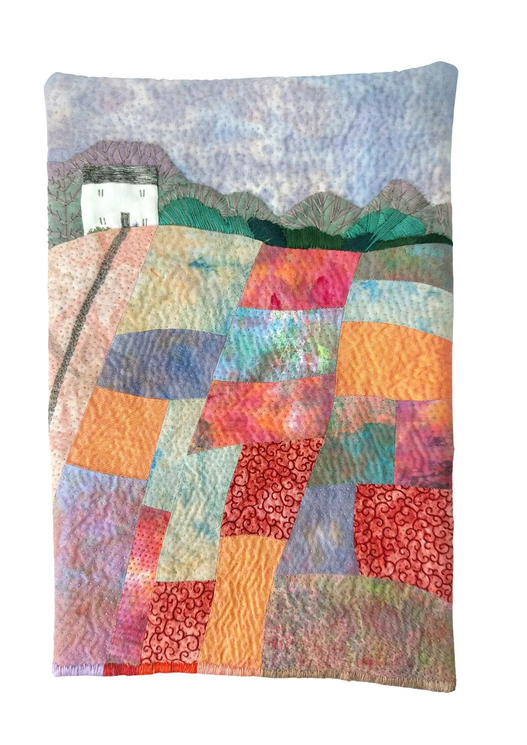 Colourful quilt with a patchwork design of various fabric pieces, depicting a rural landscape a cottage, trees, and a sky.