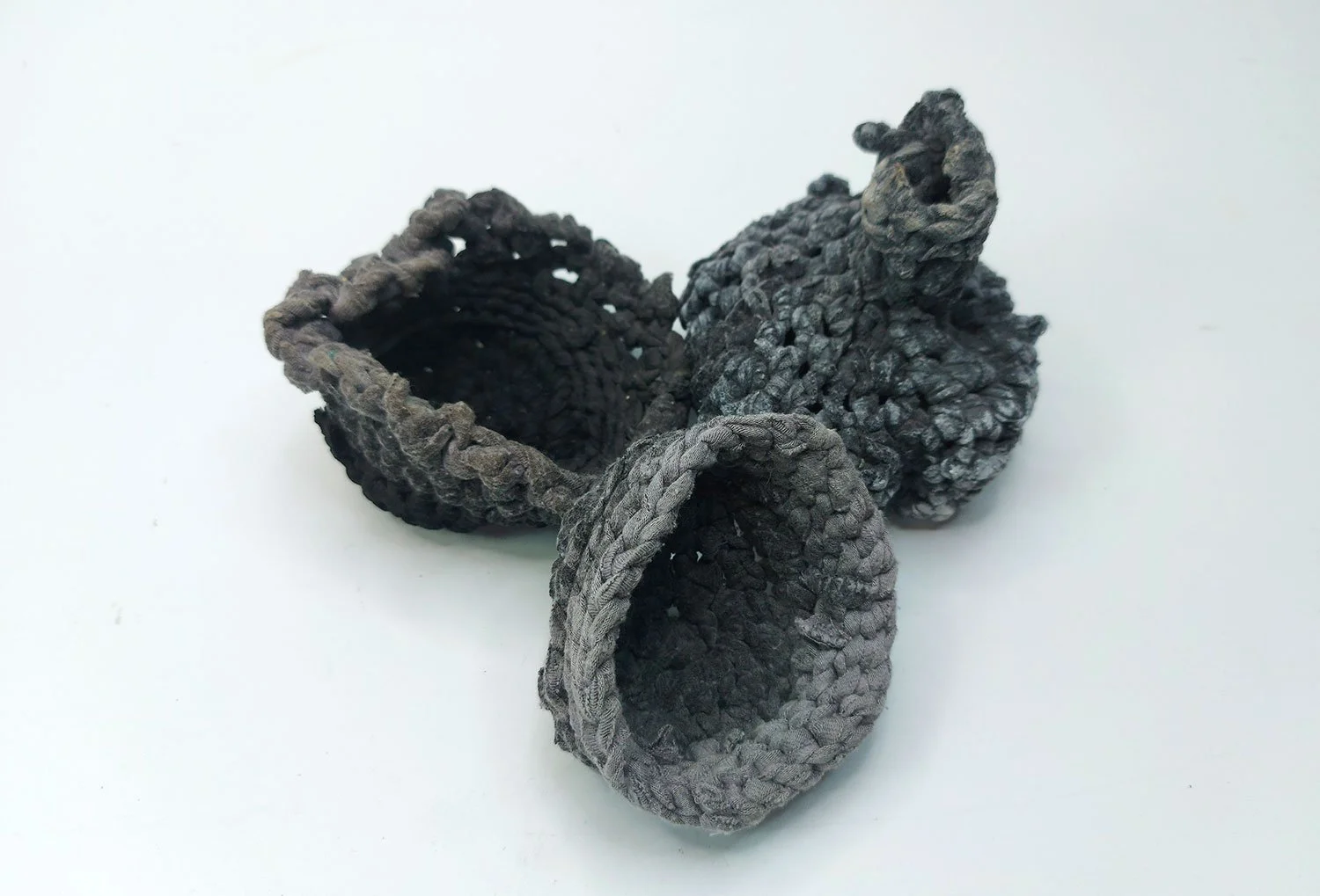 Small handmade fabric vessels in black and grey.