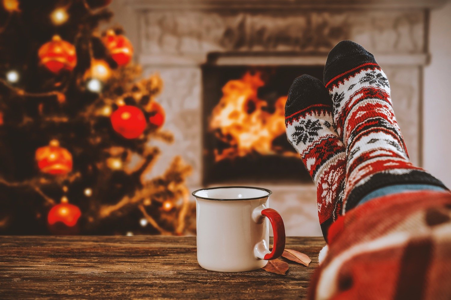 Woman legs with christmas socks and fireplace in home interiro.jpeg