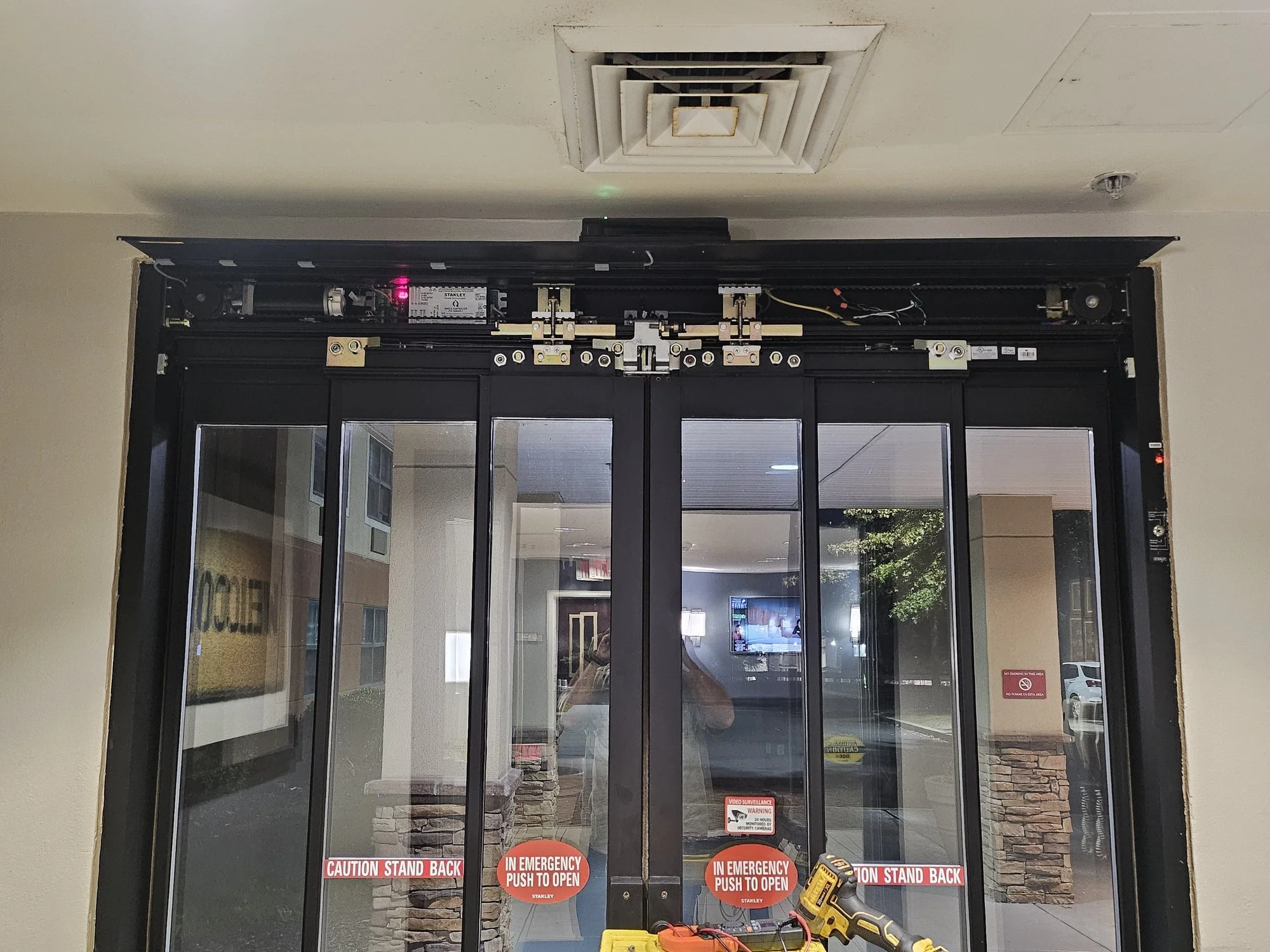 Technician servicing an automatic sliding door operator at a Connecticut hotel