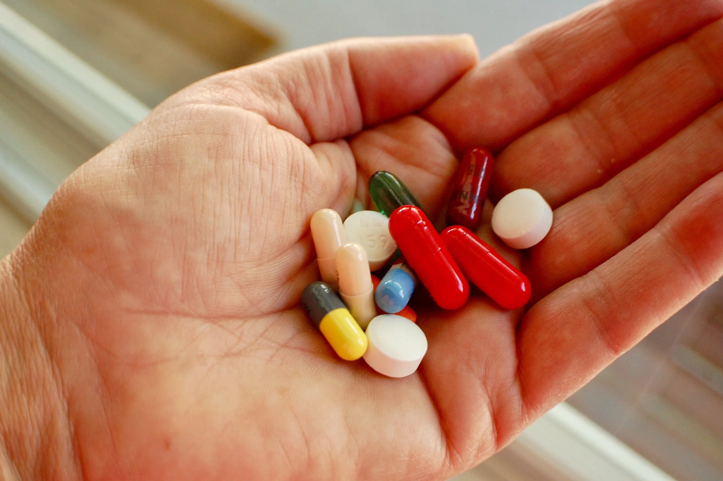 hand-holding-various-medications-2022-11-09-07-56-47-utc.jpg