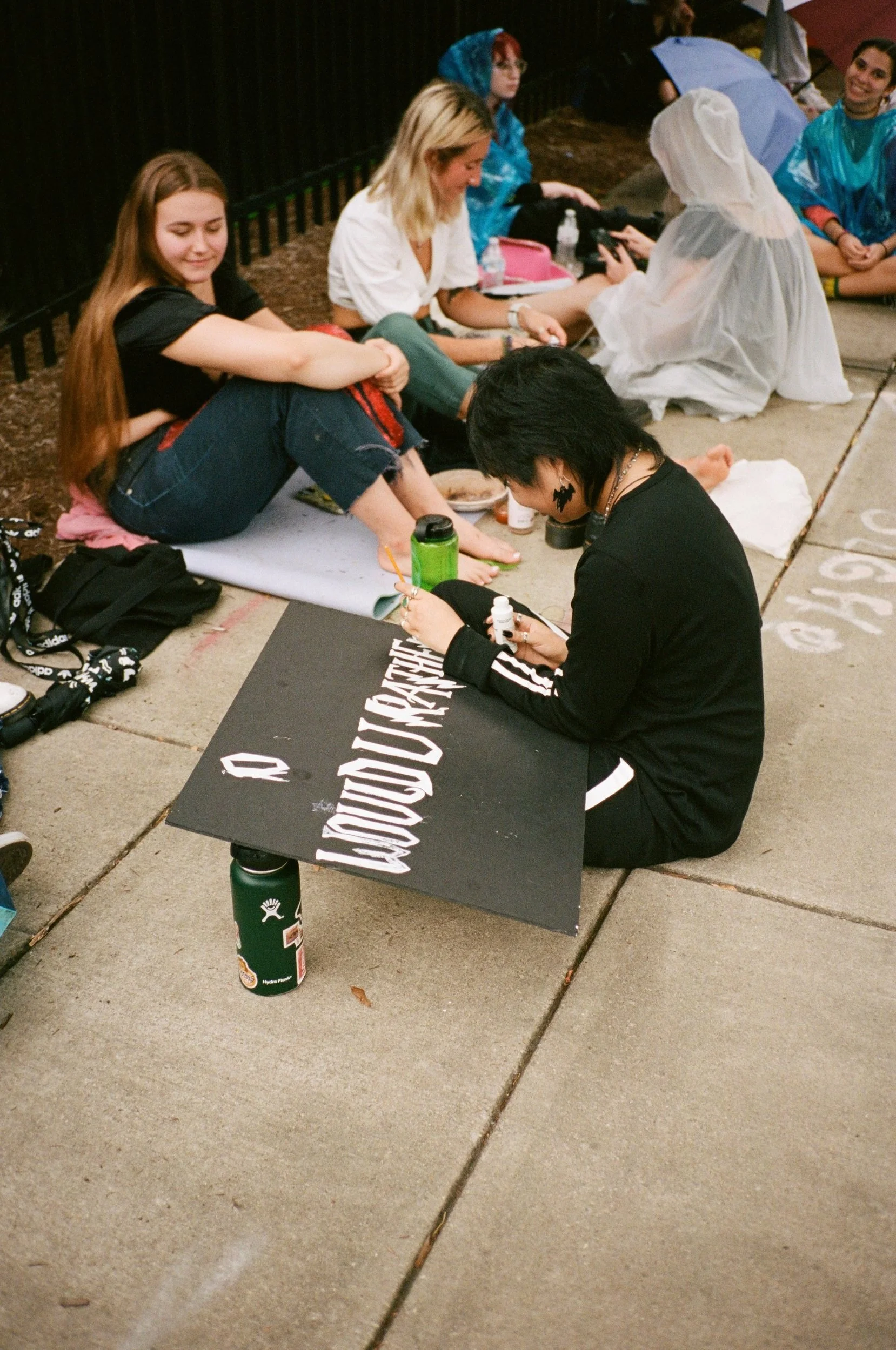 Painting a sign while waiting in line.