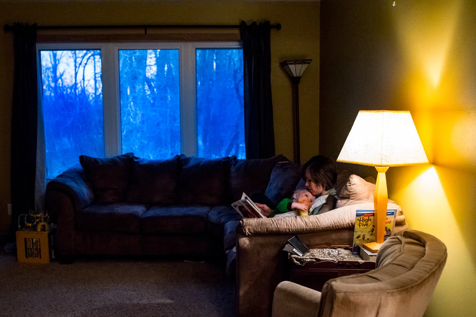 mother reads bedtime story to toddler on couch