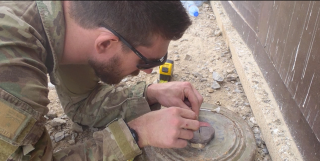 Ash Semmens carefully disarming an explosive device during his service as a Navy Clearance Diver.PNG