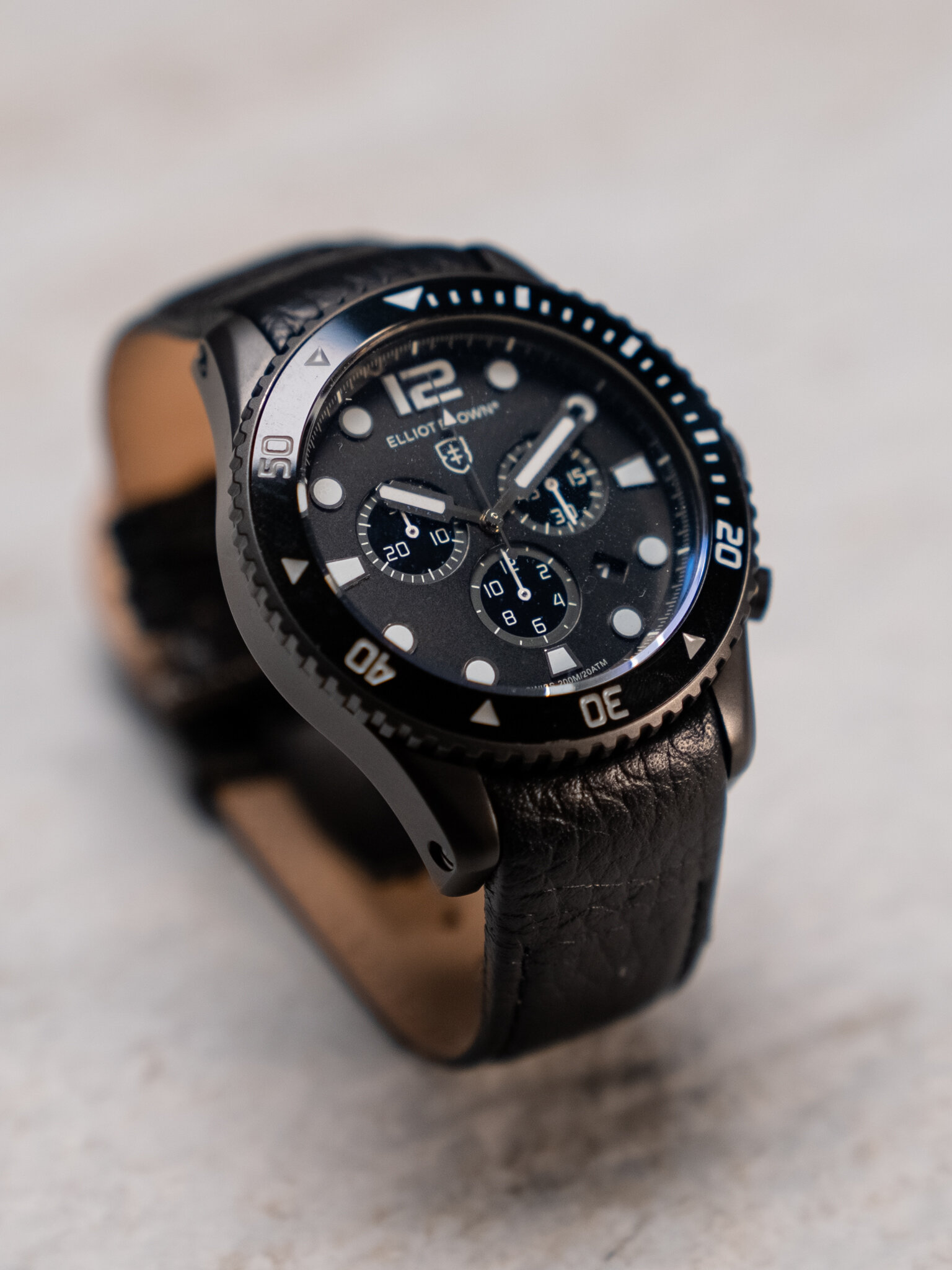 Black wristwatch with leather strap and chronograph features
