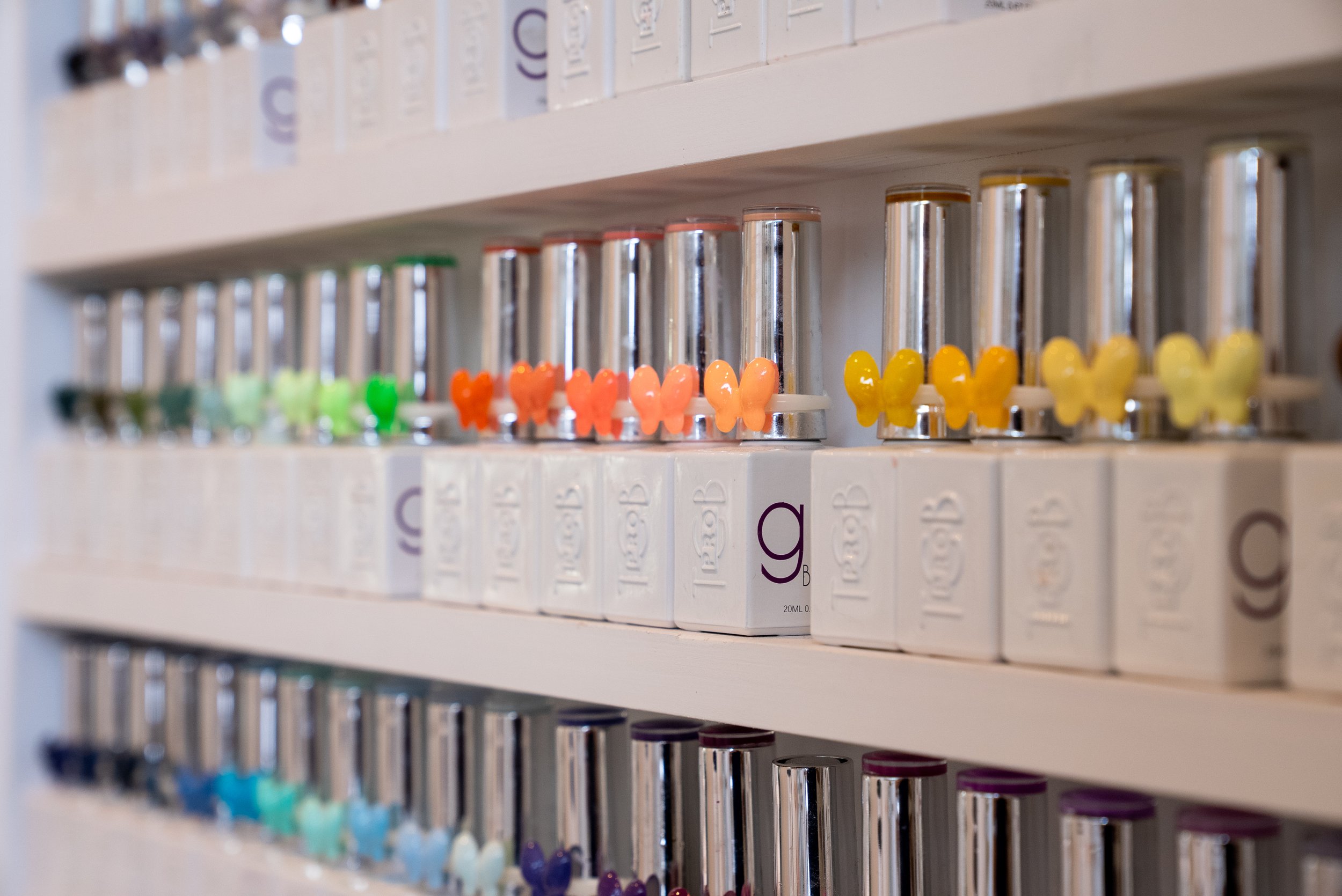 Shelf with colorful nail polish bottles in various shades