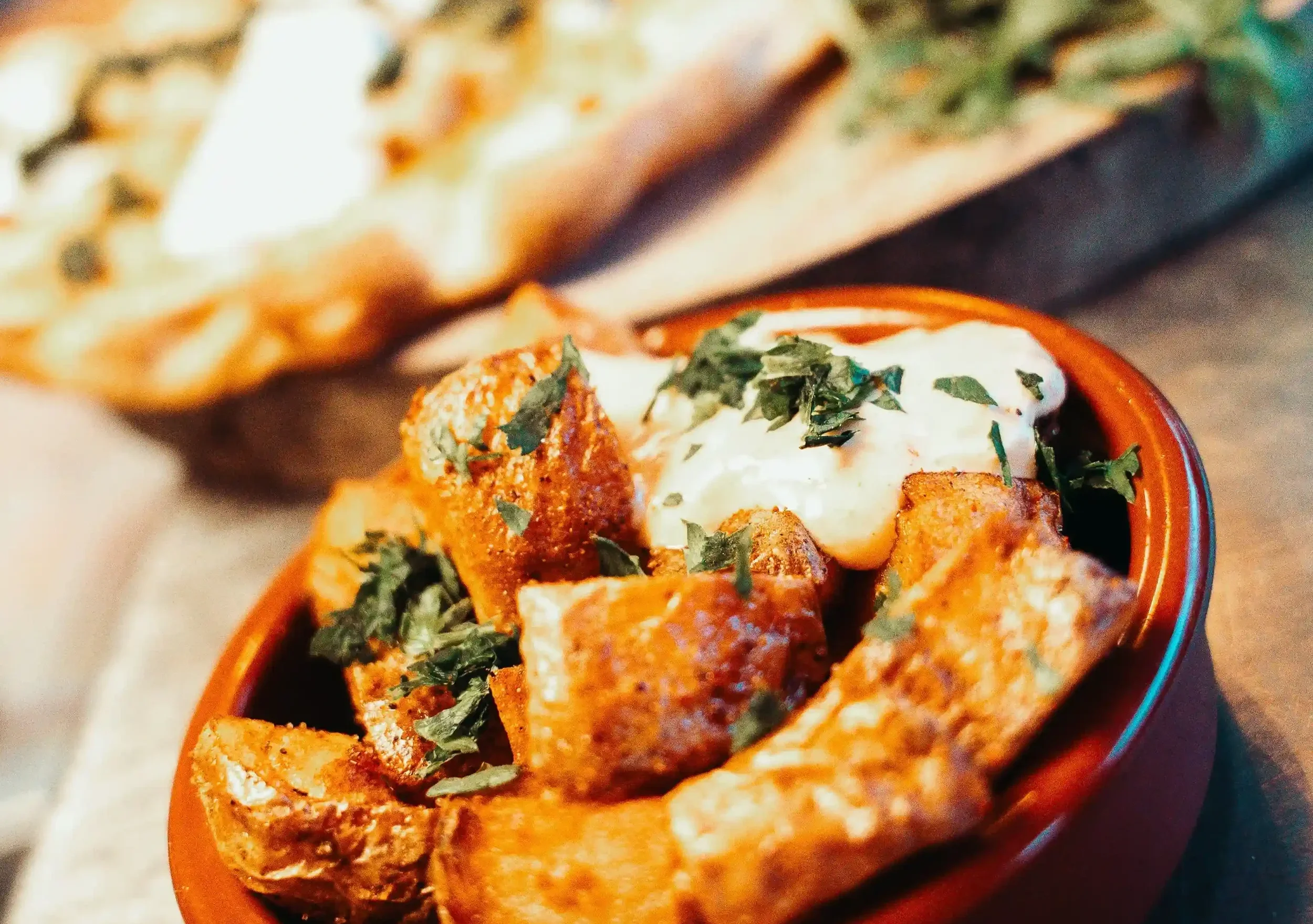 Un plat de tapas avec une pizza au fond de l'image à la Friche Gourmande Toulouse