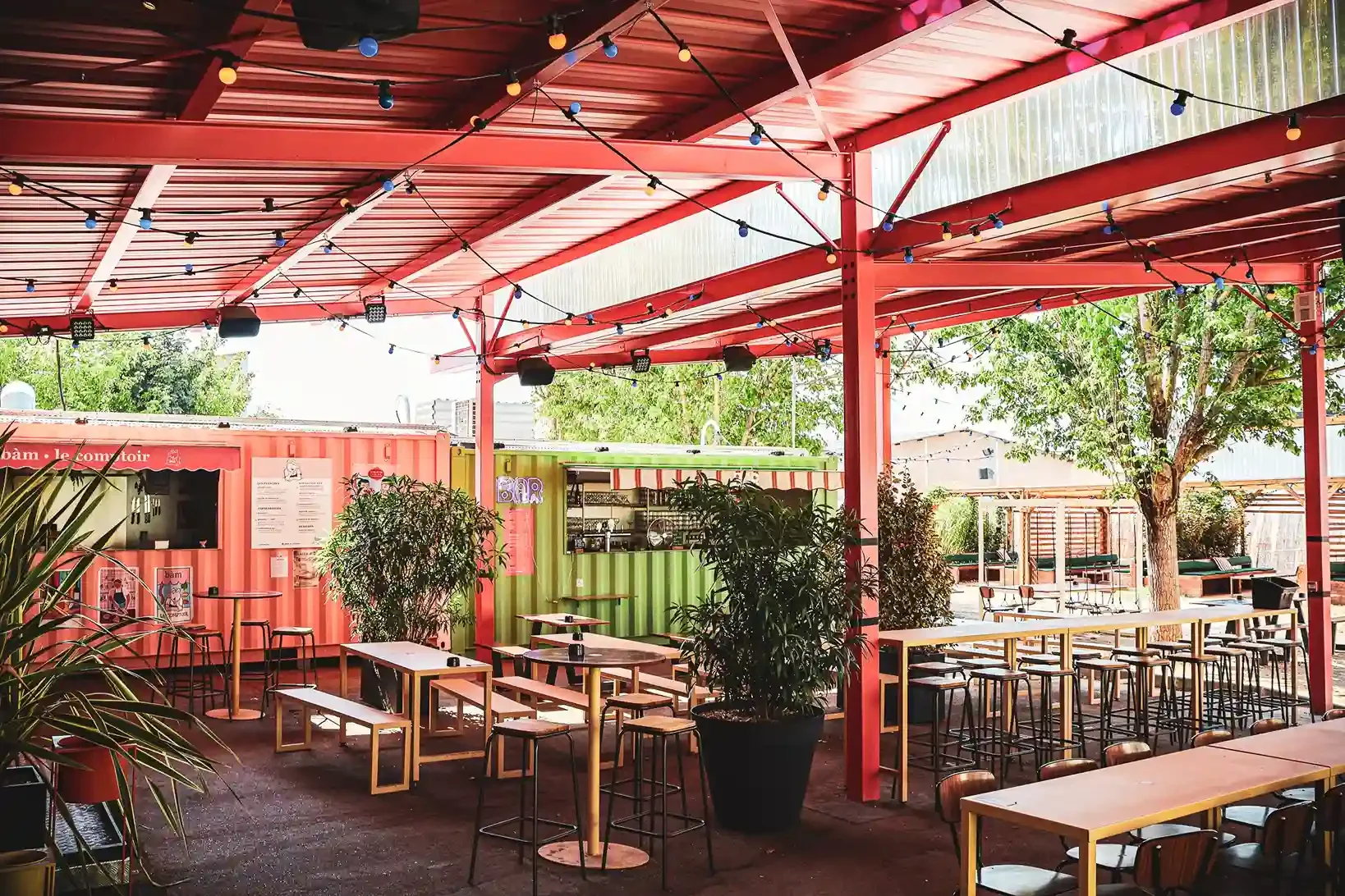 Terrasse couverte avec deux stands et des tables vides.