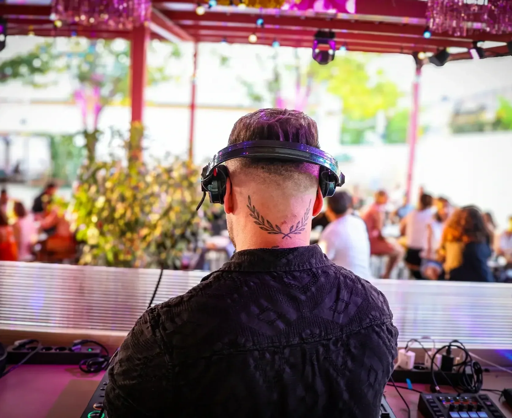 Un dj de dos en train de mixer sur la terrasse de la Friche Gramont Toulouse.