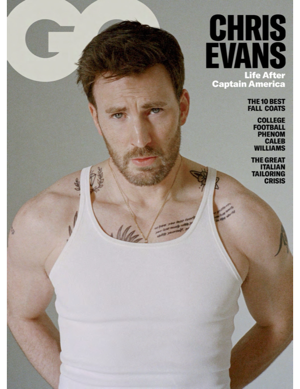 Chris Evans on the cover of GQ magazine, wearing a white tank top, with tattoos on his arms and chest, looking at the camera with a serious expression.