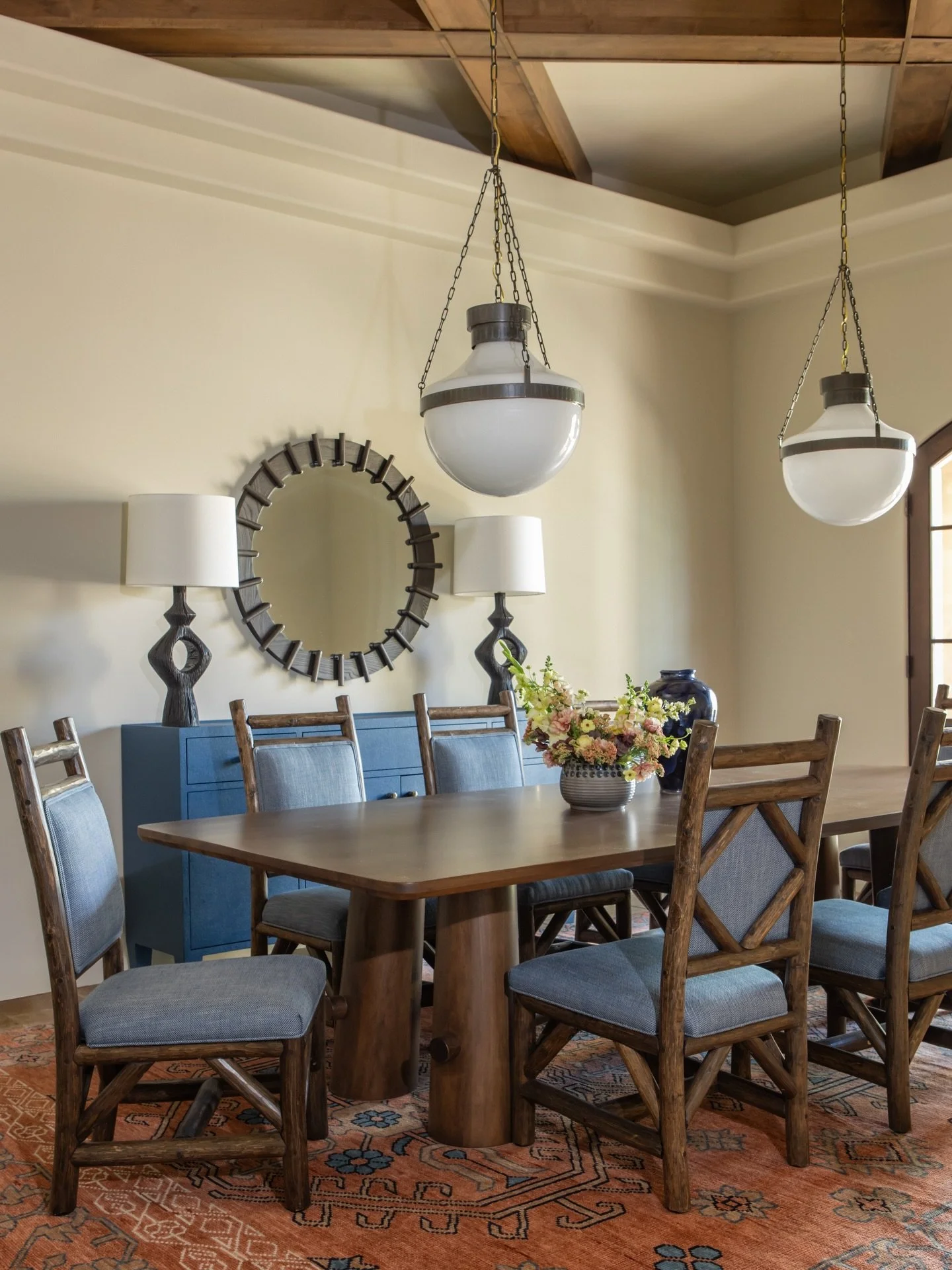 A dining room designed with intention and personality. 

This custom dining table anchors the space beautifully, paired with dining chairs thoughtfully sourced from our clients home state for a meaningful, curated feel.  A vintage inspired adds warm 