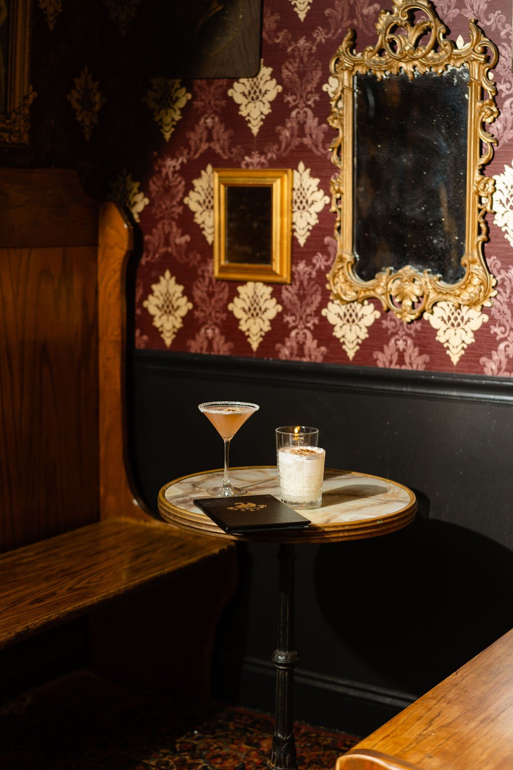 The intimate Vault with patterned wallpaper, vintage mirrors, and cocktails