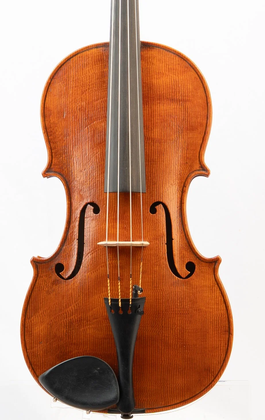 A wooden violin with a chin rest and four strings, set against a plain white background.