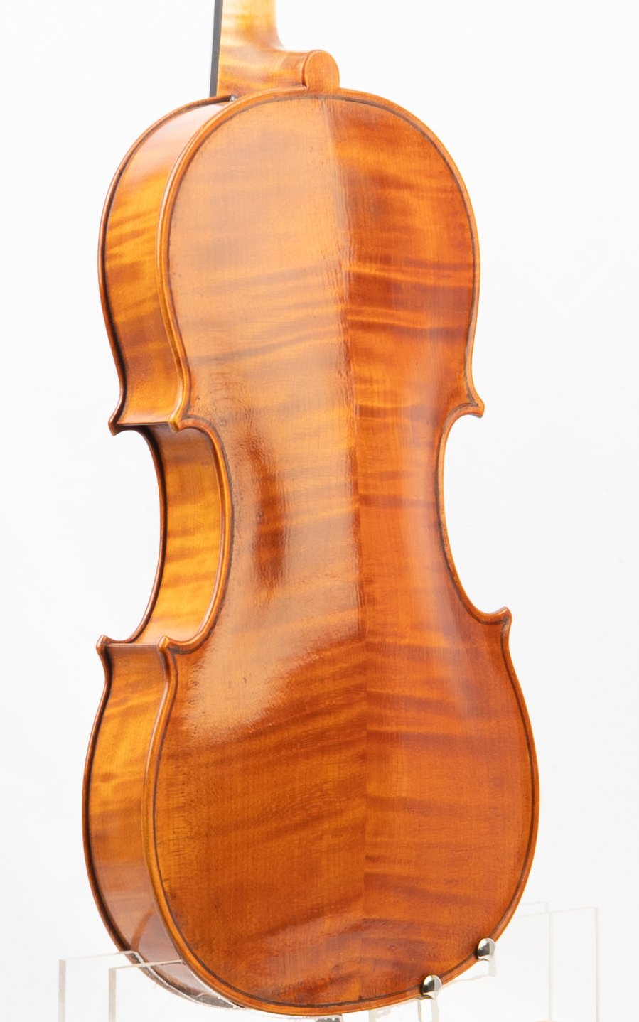 A close-up of a polished wooden violin back with a rich, warm brown finish, showcasing the wood grain and craftsmanship.