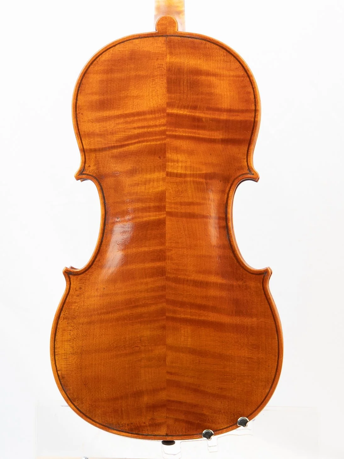 The back of a wooden violin with a glossy finish and carved details.