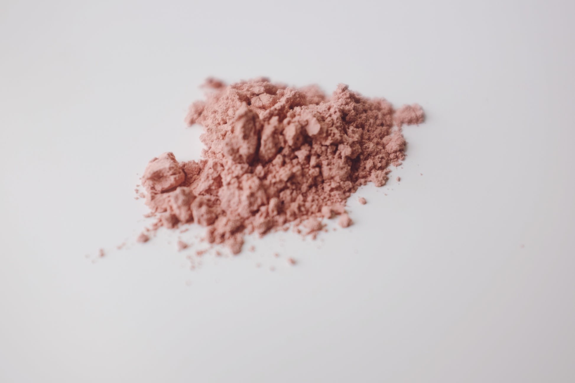 Pink Theory Clay Face Mask powder on a white surface.