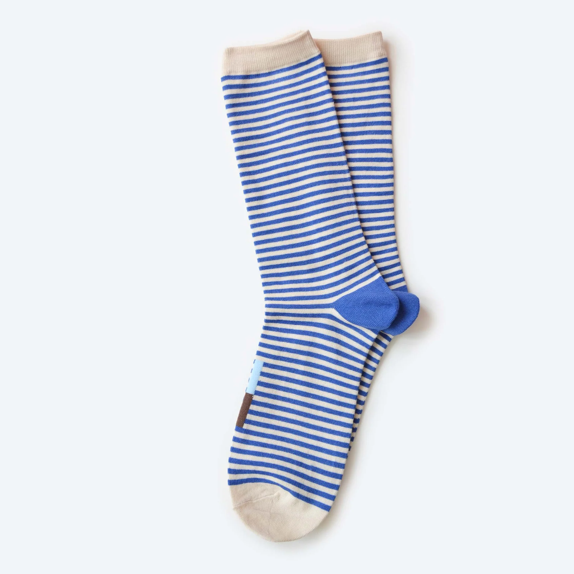 A pair of Hooray Crew Socks with blue stripes and a sky blue and brown colorblocked bar on the front of the socks.