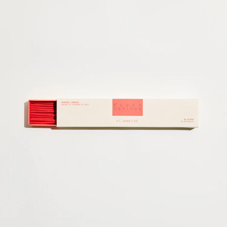 A pale yellow, drawer style box of P.F. Candle Co. Plush Vetiver HI-FI Incense Sticks, slightly open to reveal red incense sticks.