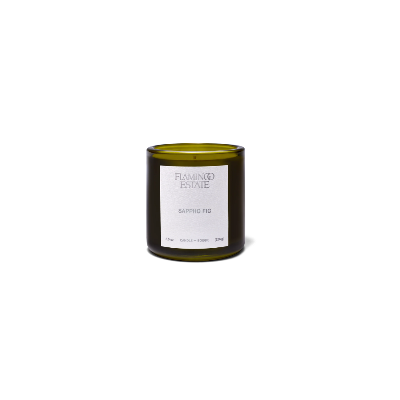 A dark green glass jar with a white label, containing Flamingo Estate Sappho Fig Candle.