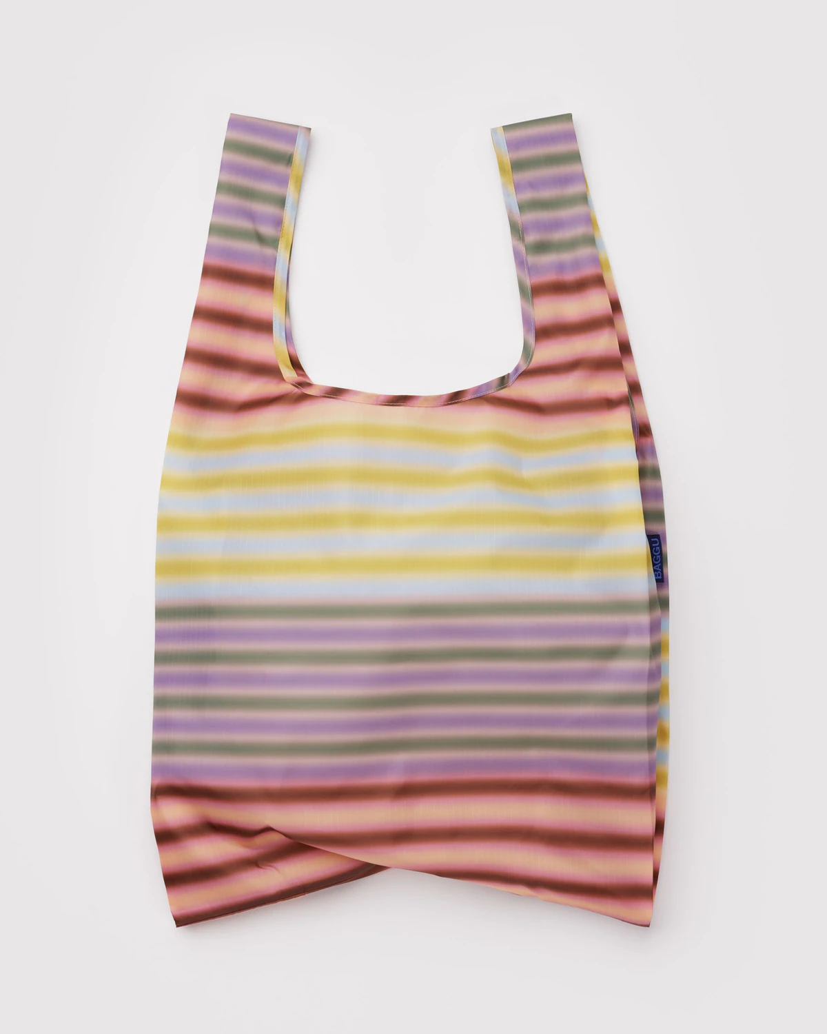 Baggu Gradient Stripe Multi Standard Baggu, a reusable nylon tote with muted, gradient stripes in peach, pink, burgundy, purple and green.