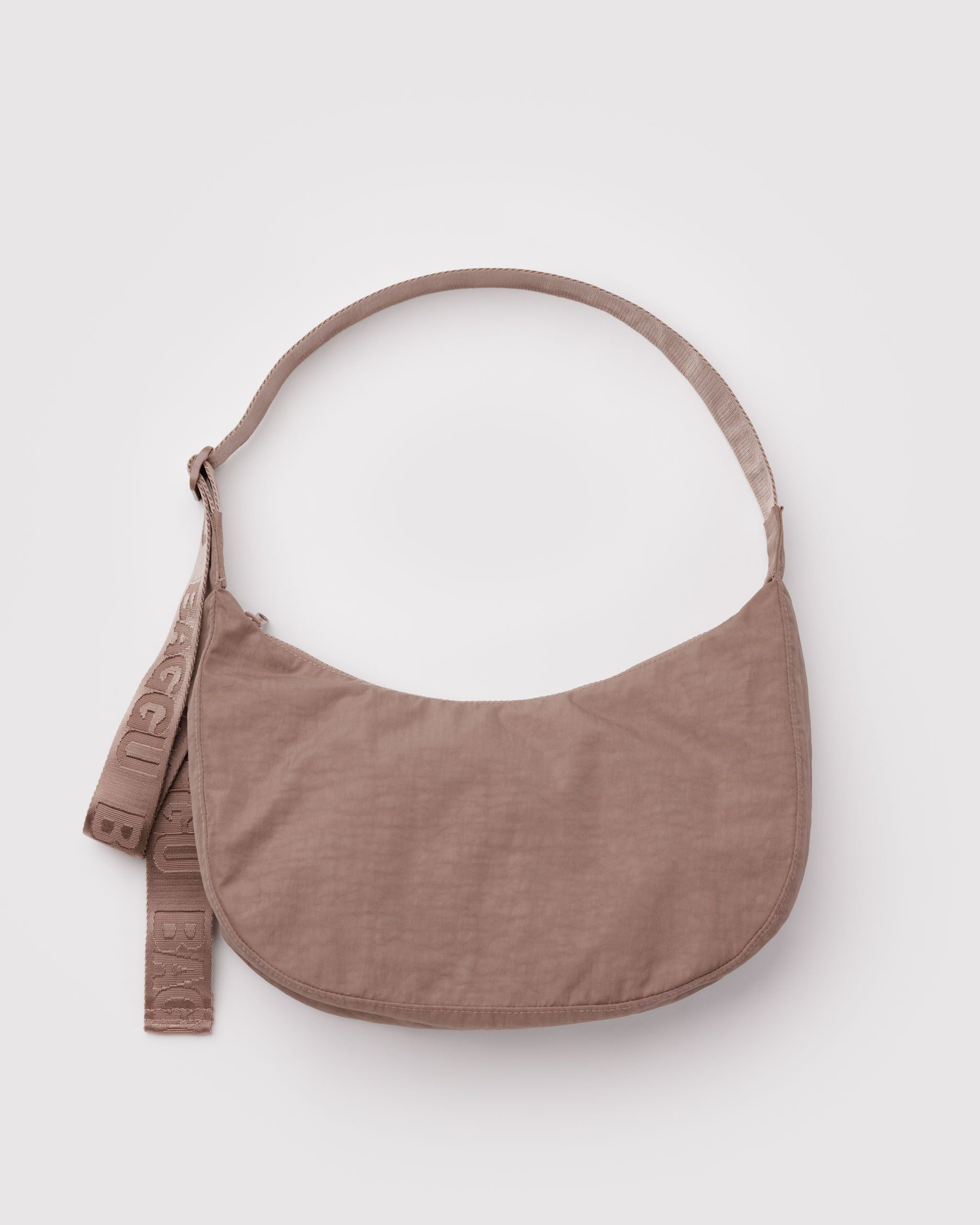 Baggu toasted almond.pnBaggu Crescent Bag in khaki nylon with a khaki nylon strap on a white background.