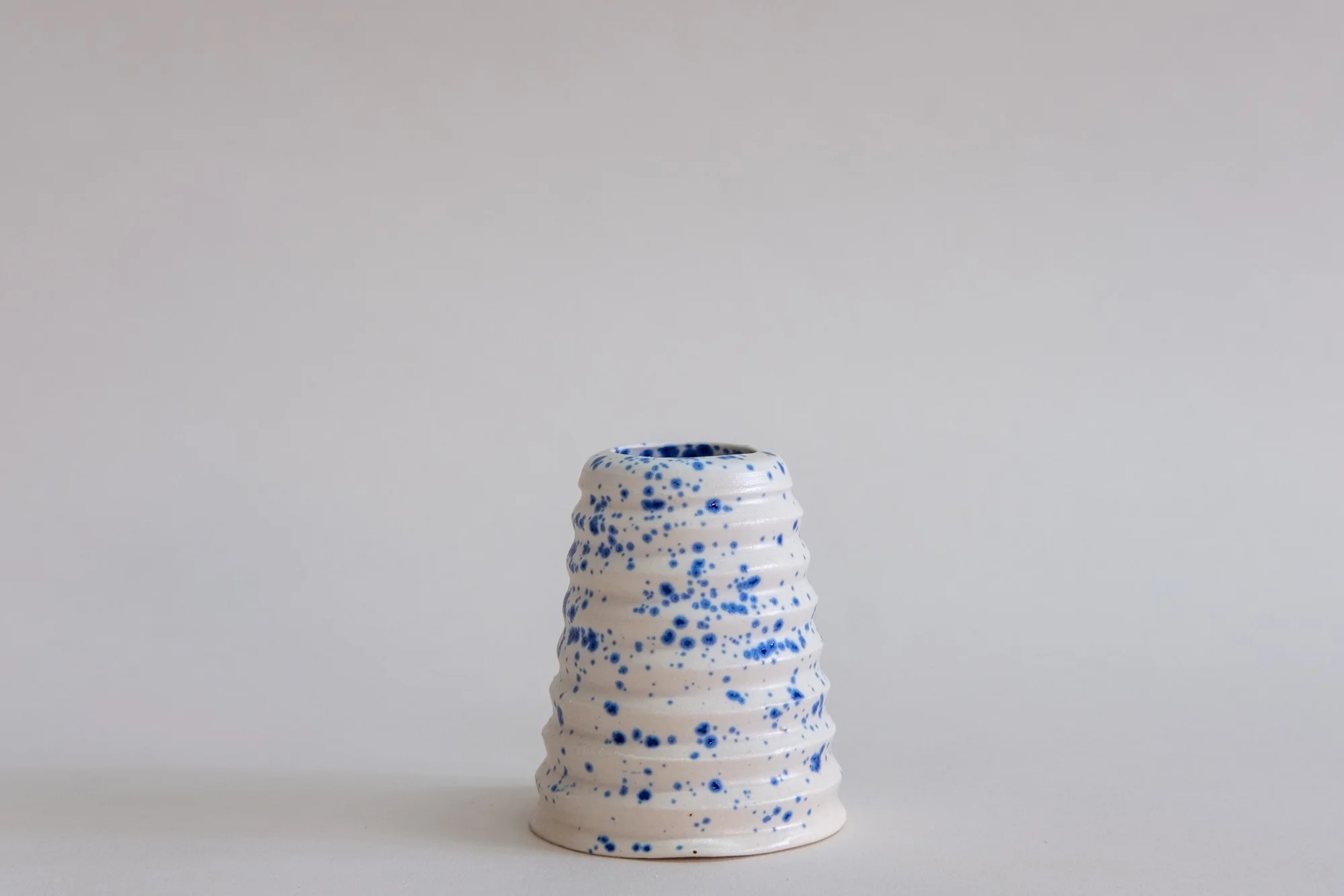 Utility Objects Speckled Blue Everything Vessel, a blue speckled vessel with horizontal ridges.