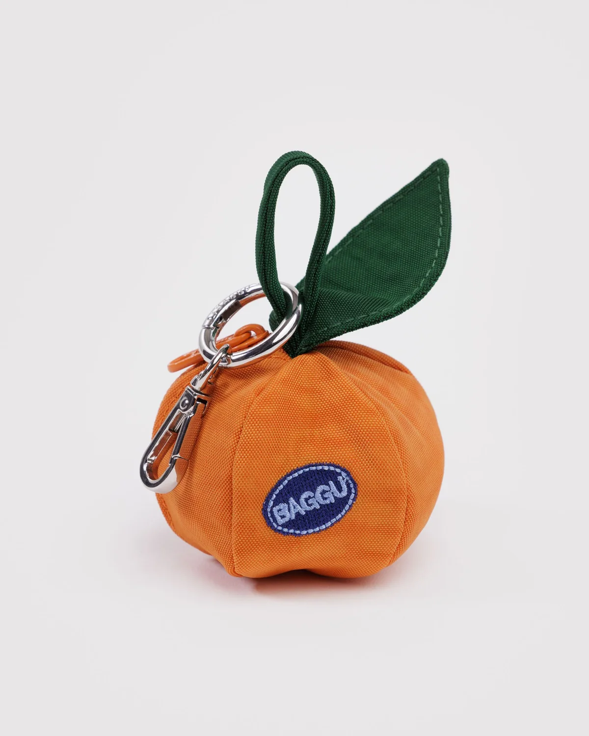 Baggu Mandarin Charm, a round, orange, zippered pouch with a green leaf and a silver keychain attachment.