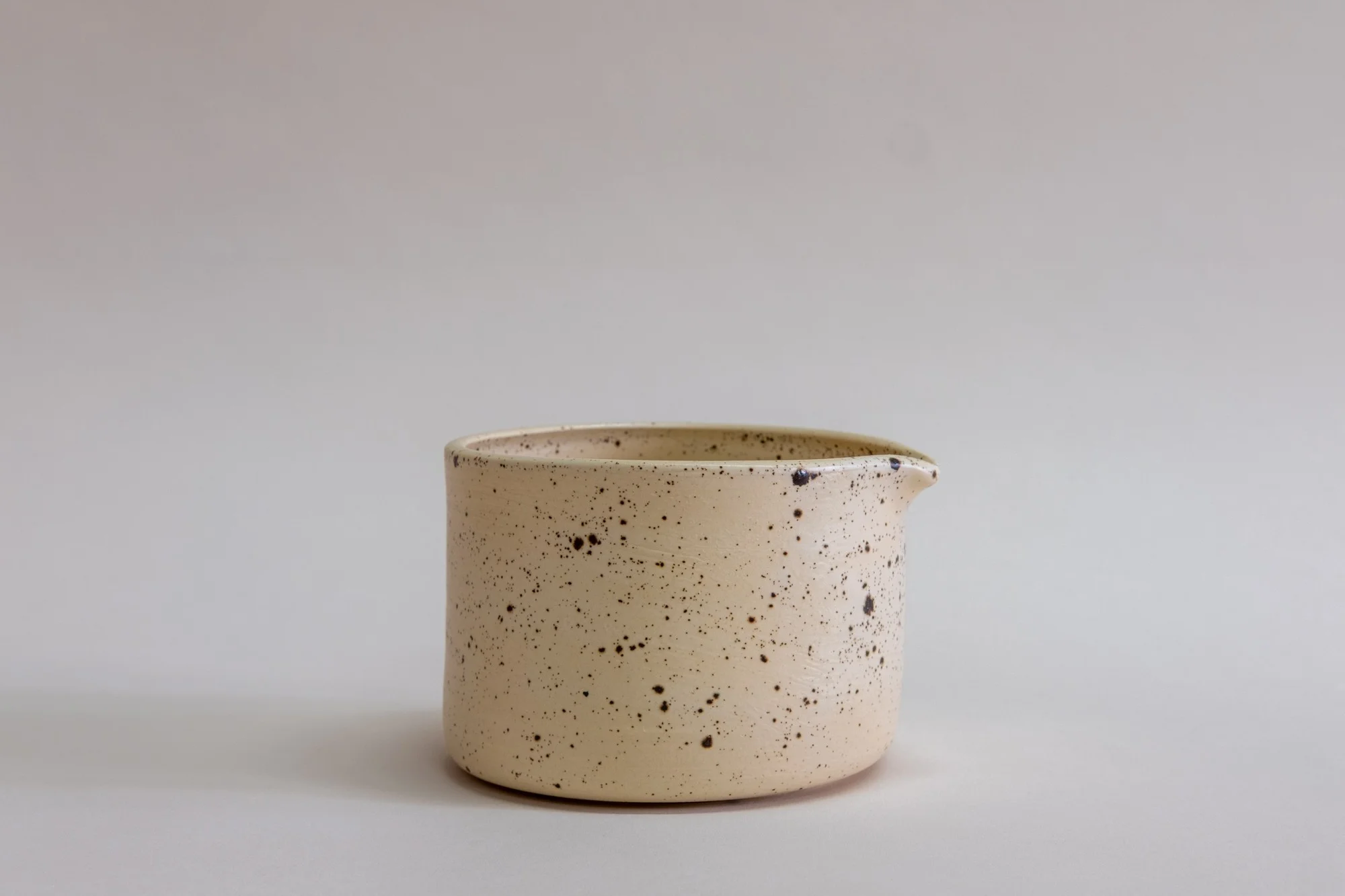 Utility Objects Eggshell Chawan Bowl, a natural ceramic bowl with a brown speckles and a spout.