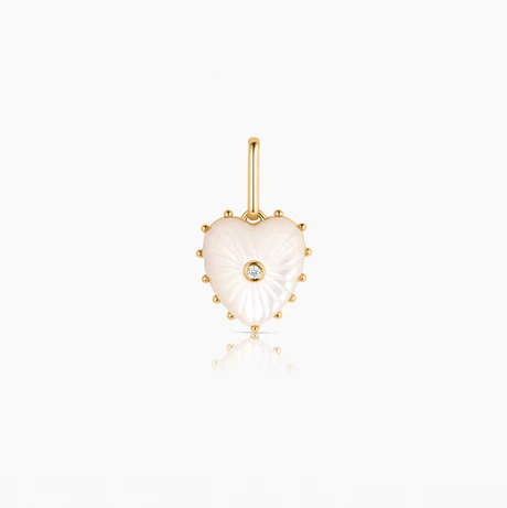 The Thatch Mother of Pearl Heart Charm, a mother of pearl heart-shaped charm with a sparkling stone at the center, with 14K gold plated details.