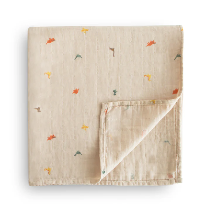 A cotton muslin swaddle with tiny, various color dinosaurs folded into a square.