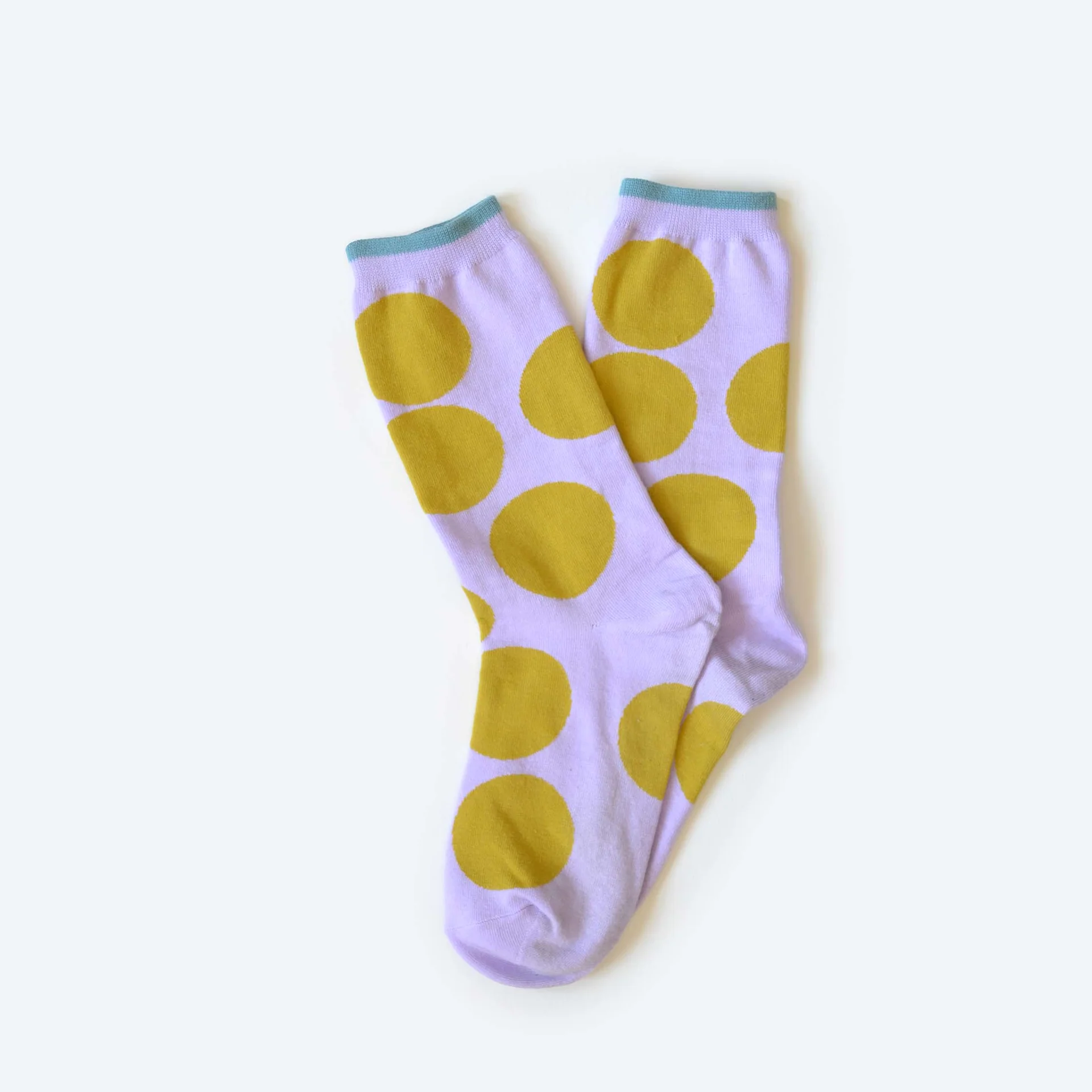 A pair of Hooray lavender crew socks with big chartreuse polka dots.