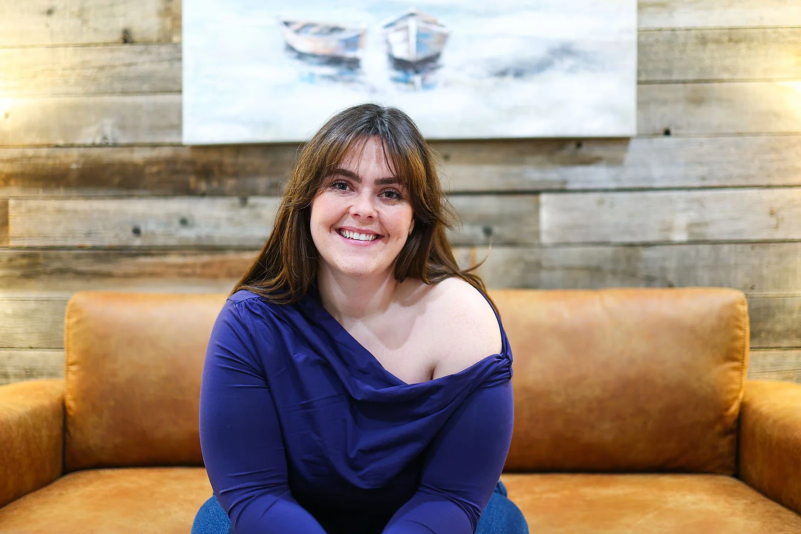 Warm therapist seated in counselling office at Bloom Narratives Airdrie