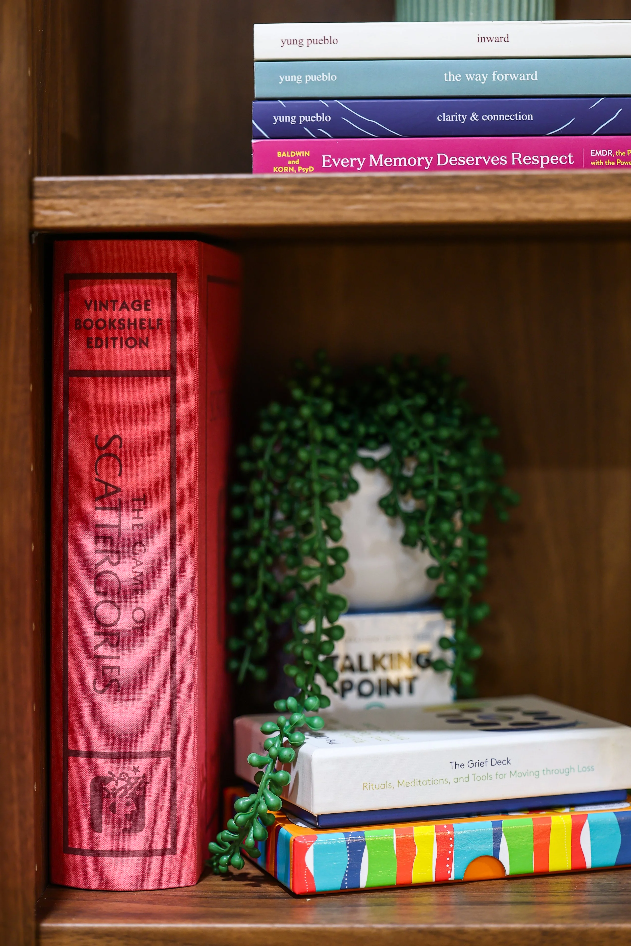 Bookshelf in Bloom Narratives therapy office with mental health and wellness resources