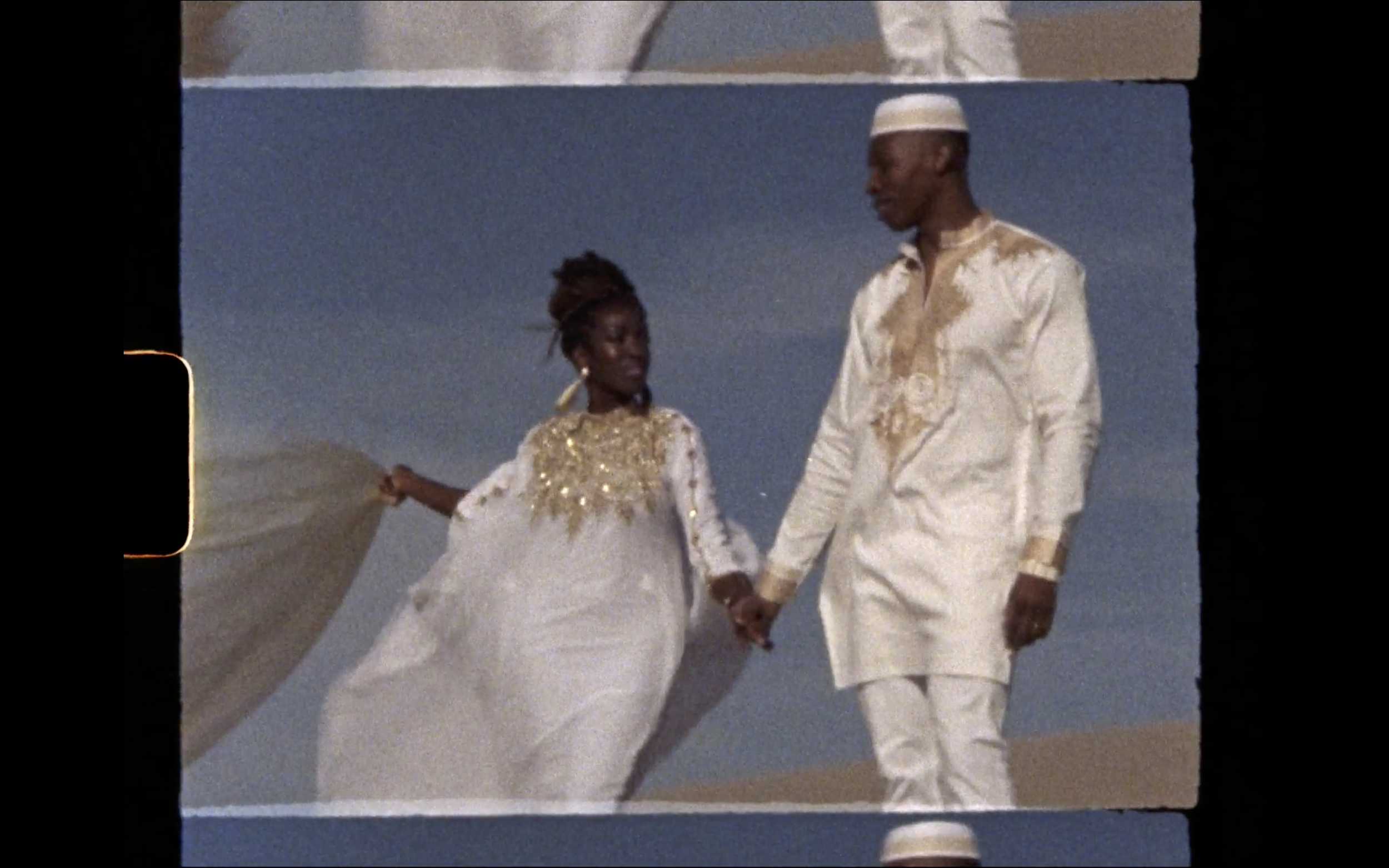 Super 8 screenshot of an African couple on their wedding day in sand dunes in Utah Polaroid film video by Andrea Vodickova
