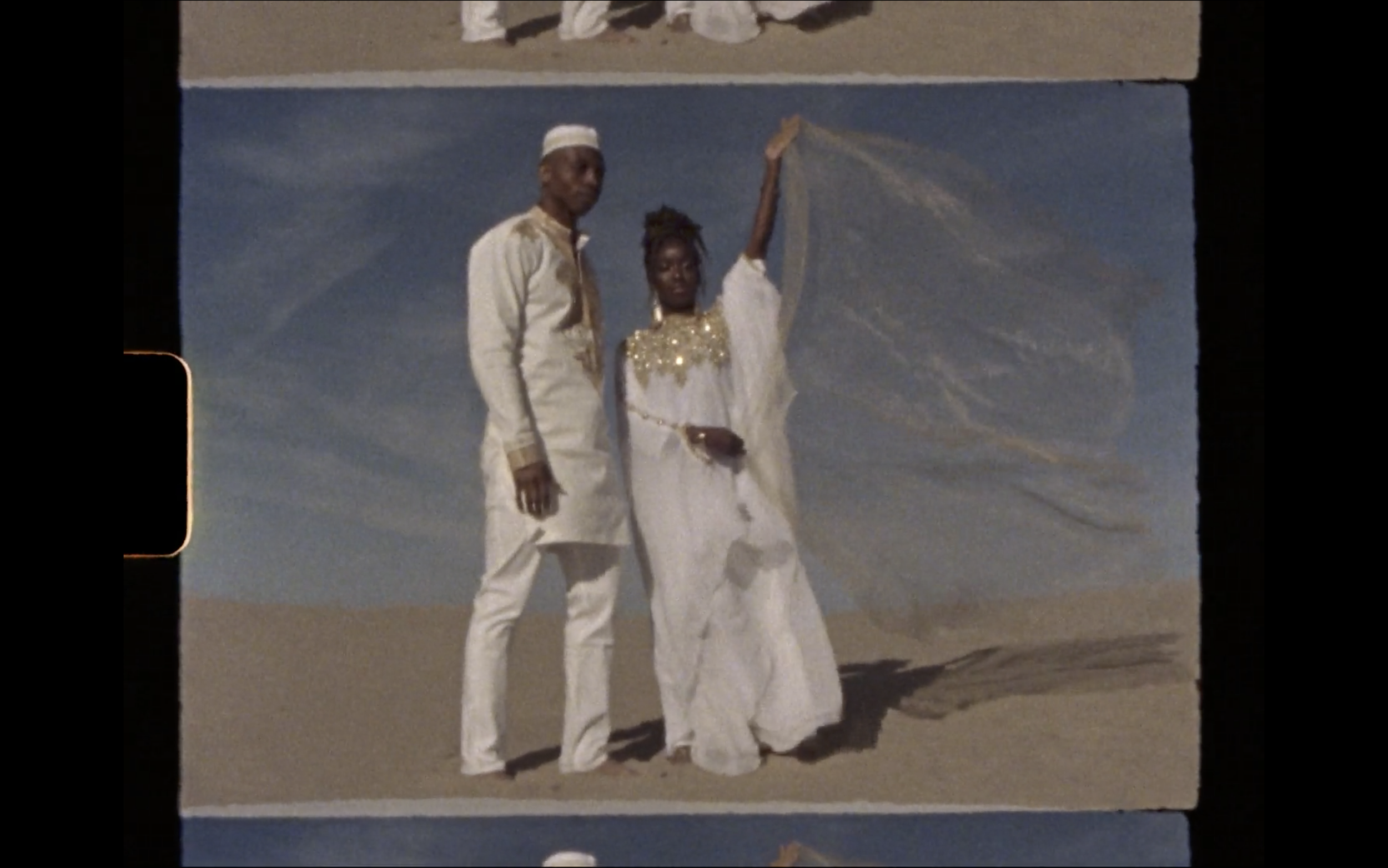Super 8 screenshot of an African couple on their wedding day in sand dunes in Utah Polaroid film video by Andrea Vodickova