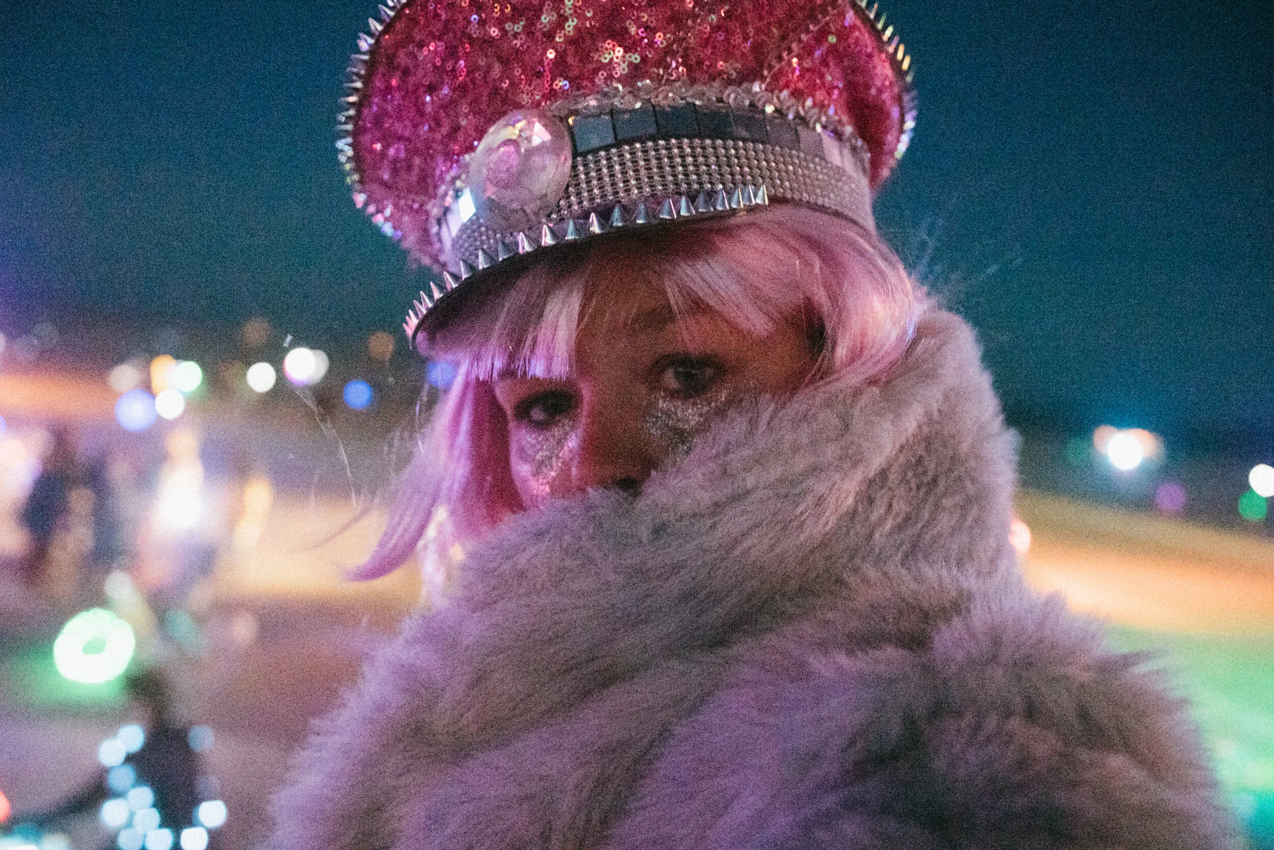 ANDREA VODICKOVA at Burning Man wearing a pink hat and pink wig in a fur coat