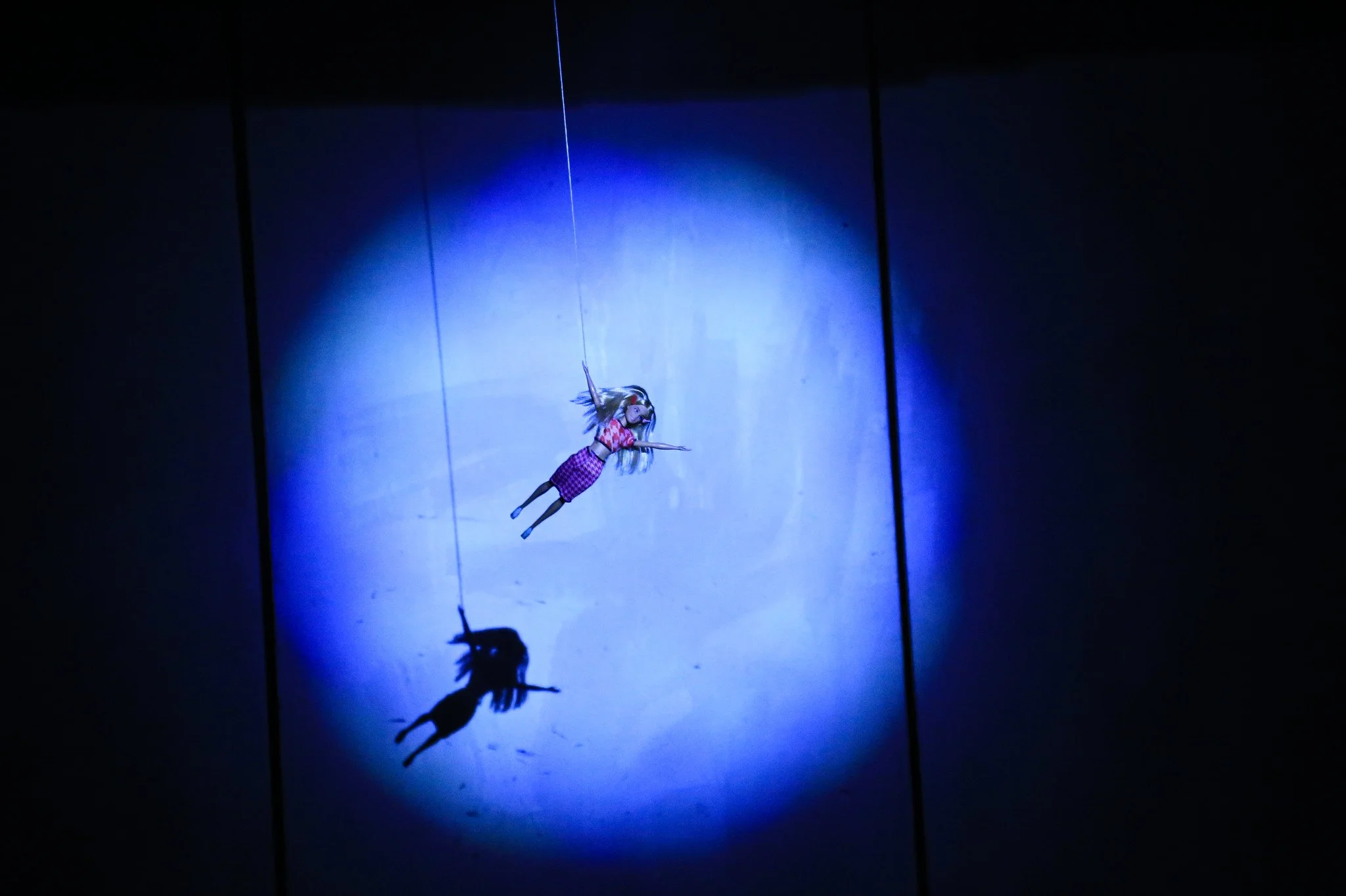 Spot lit Barbie doll hanging from a string.jpg