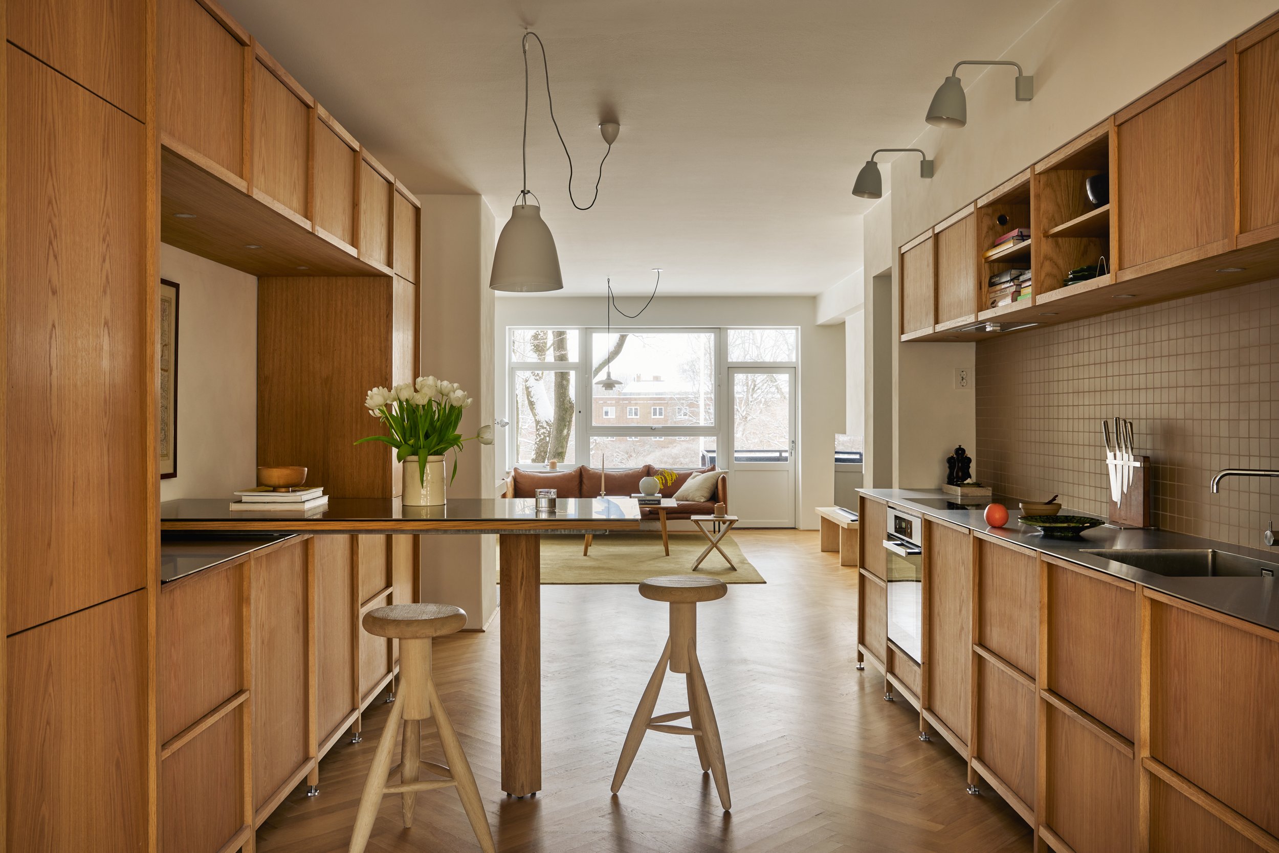 Ettersom kjøkkenet ble plassert i et mellomparti, var det viktig å få innredningen til å fremstå som et selvstendig møbel og ikke som en integrert kjøkkenløsning. Innredningen er løftet opp på stålben som gjør at dagslyset finner veien inn under skap