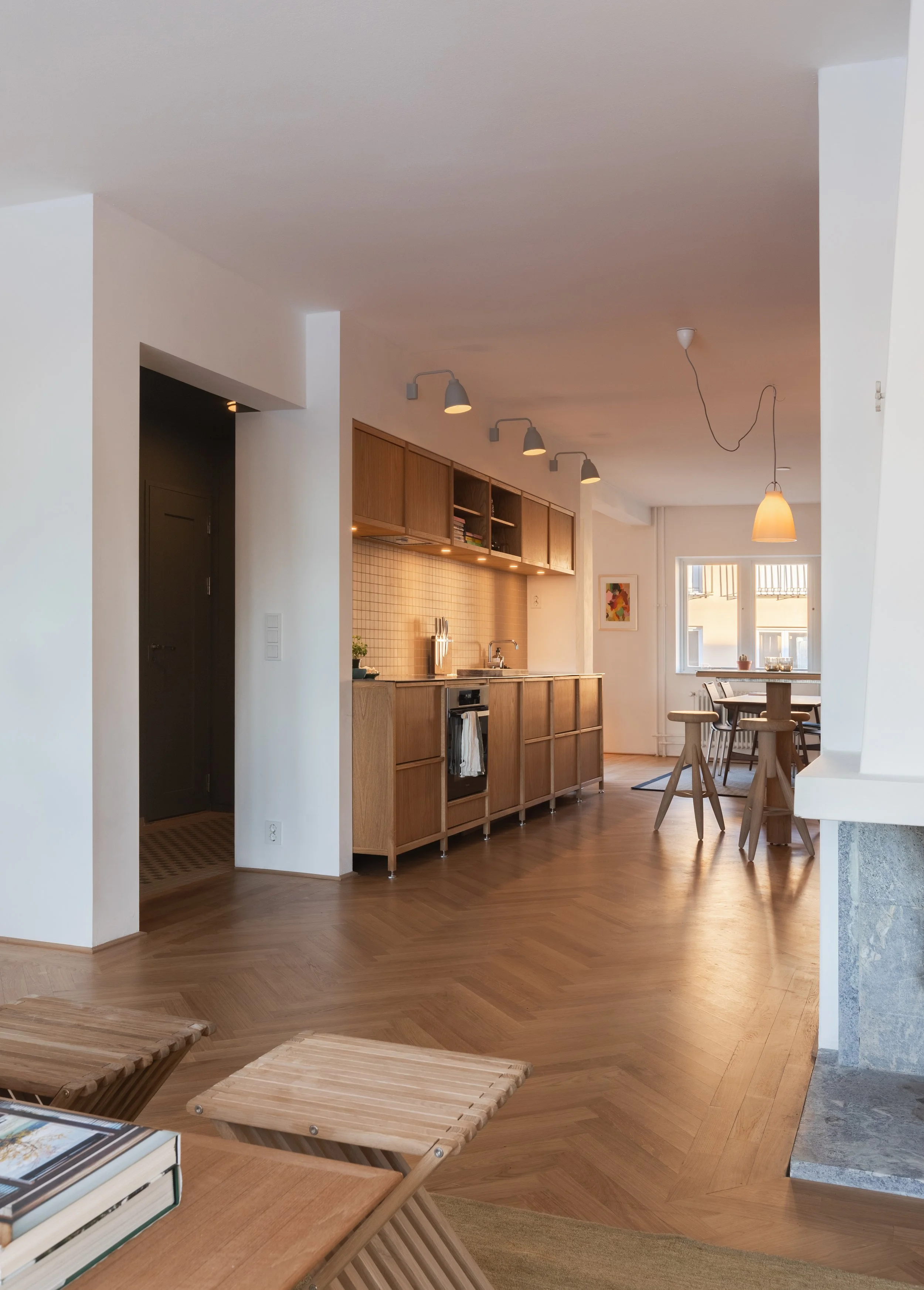 Kjøkkenet ble lagt til den mørkeste delen av leiligheten, der innredningen er spesialtegnet til langveggene på hver side. Det gav plass til spisestue og stue langs hver endevegg med gjennomgående belysning.   