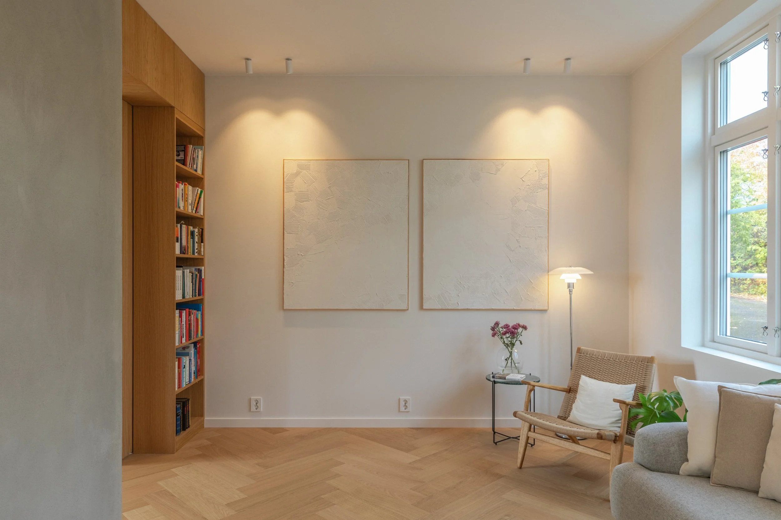 I tv-stuen er det lagt inn bokhylle i funksjonsveggen med baksiden til peisinnsatsen i forgrunnen.