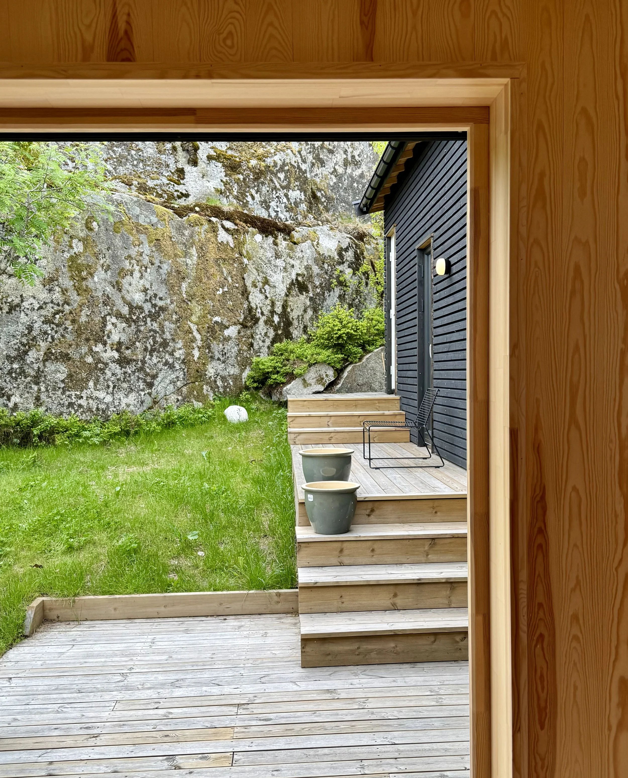 Utsyn mot atriet og bergvegg i vest, soveromsfløy skjermer mot innsyn fra nord