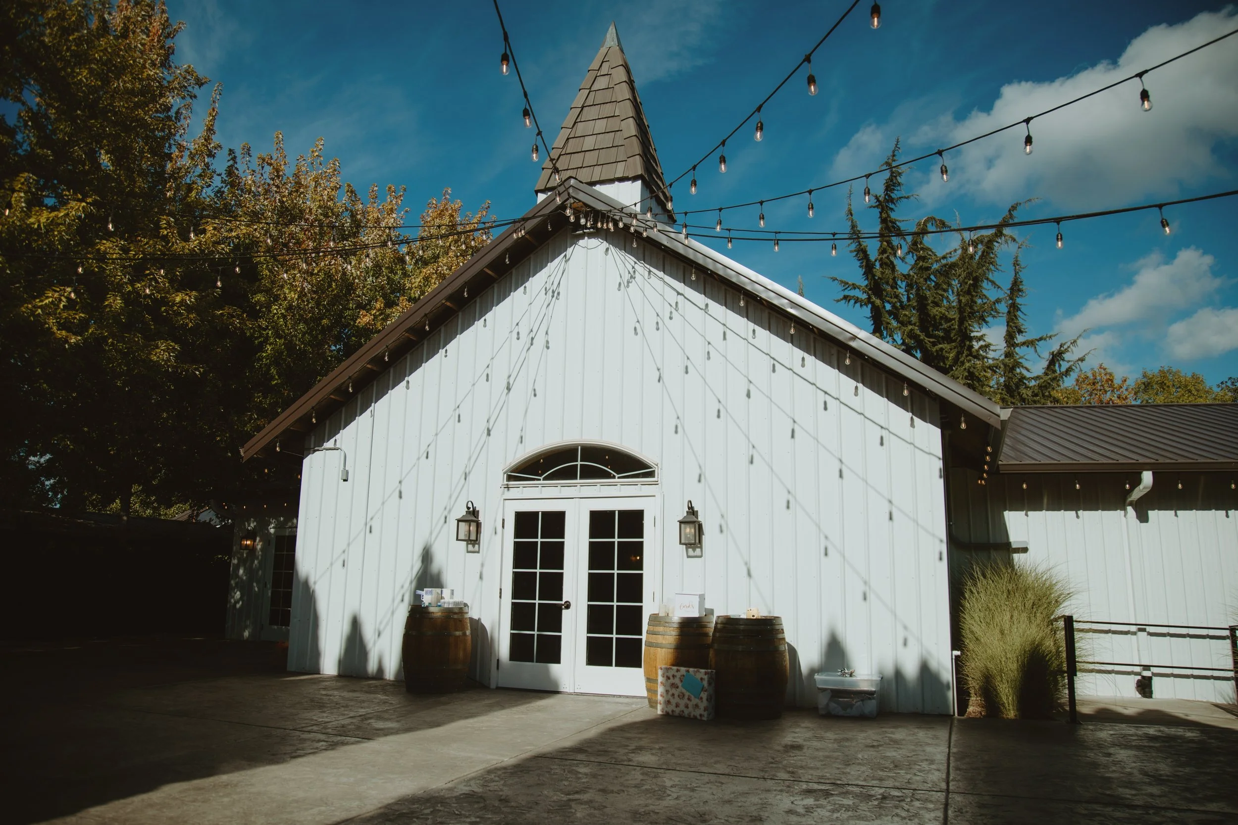 aurora vineyards main white building with pointed top and string lights attached
