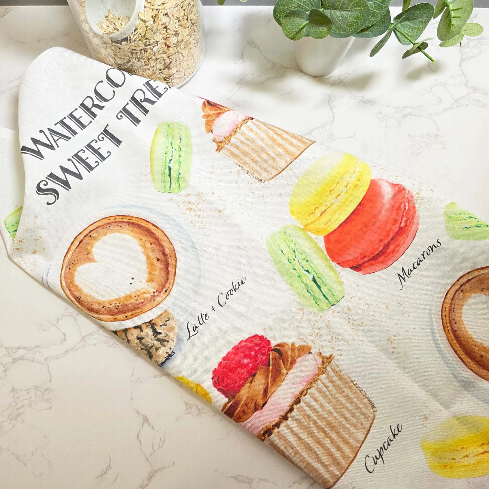 COMING SOON - A little sweetness for the heart of your home! Who says everyday essentials can't be beautiful? My Sweet Treats tea towel features my original watercolor artwork of a tempting cupcake, colorful macarons, and a comforting latte paired wi
