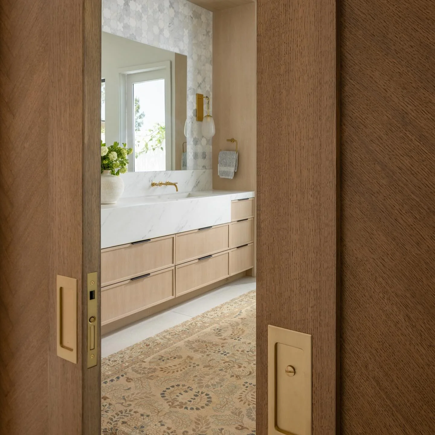 Step into this serene, elevated and fully custom primary bathroom we designed for two of our favorite clients! They requested a spacious double vanity, steam shower and an outdoor shower.  We love the texture of the marble star and cross vanity backs
