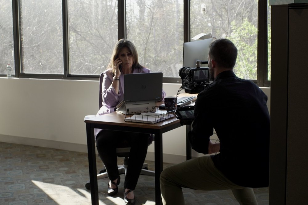 Behind-the-scenes filming at Calyx headquarters — director capturing interview with clinical researcher