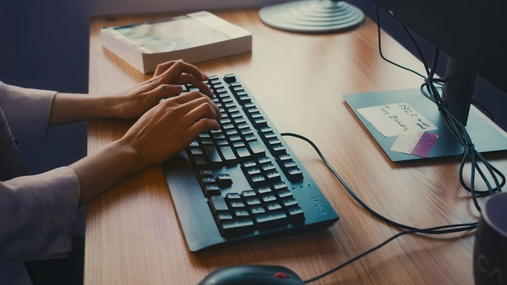 Detail shot of hands typing at desk during Calyx b-roll capture