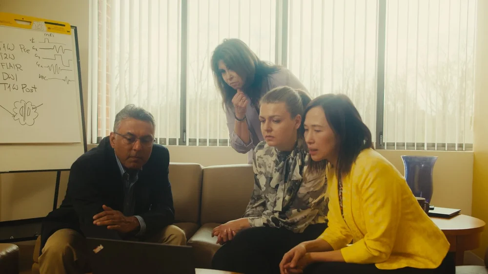 Calyx research team collaborating around whiteboard with medical imaging notes