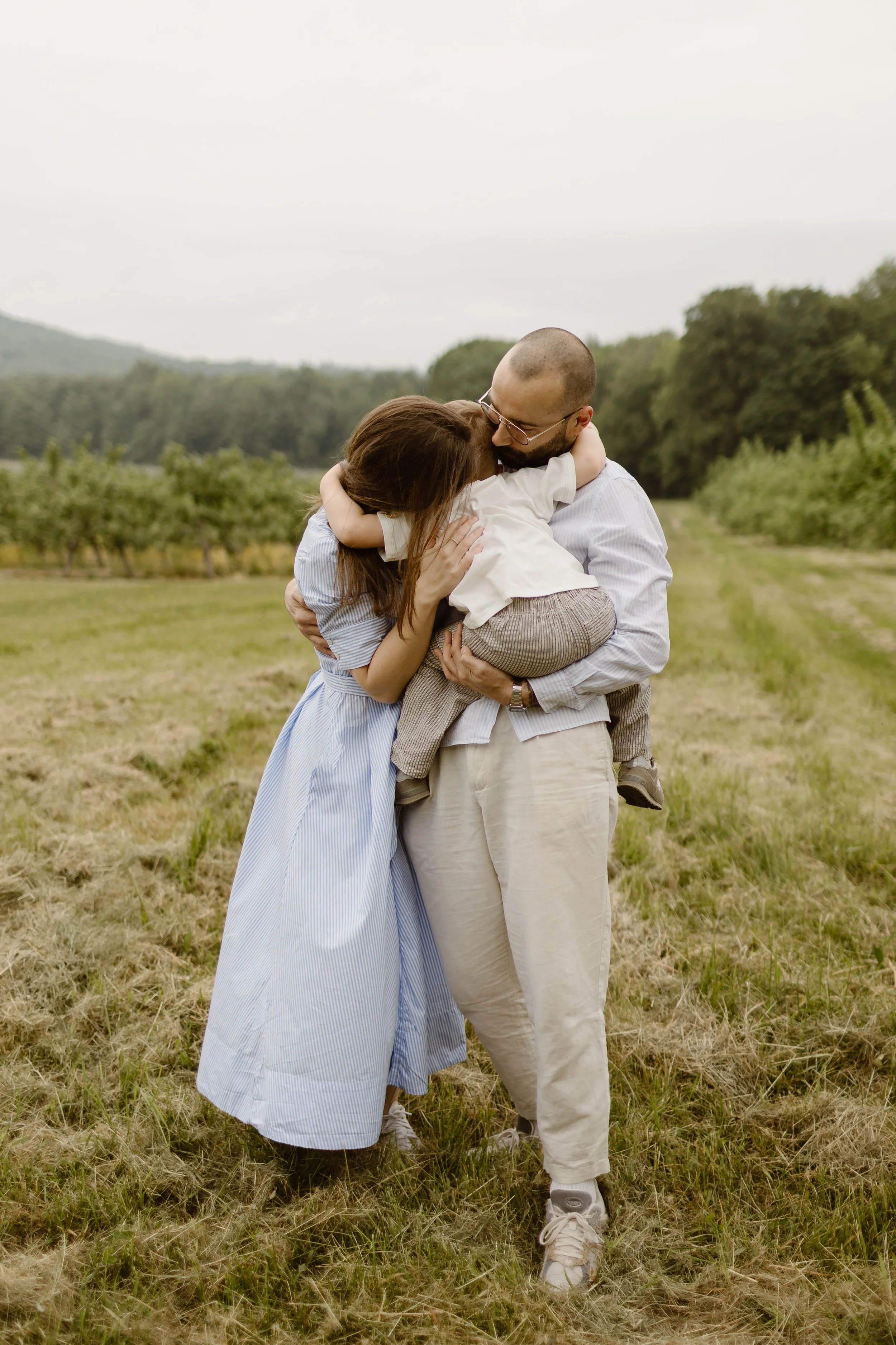 Parents et enfant qui s'embrasse dans la nature